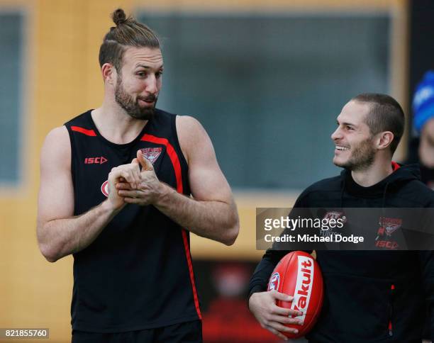 Cale Hooker reacts with David Zaharakis after speaking to media during an Essendon Bombers AFL media session at the Essendon Football CLub on July...