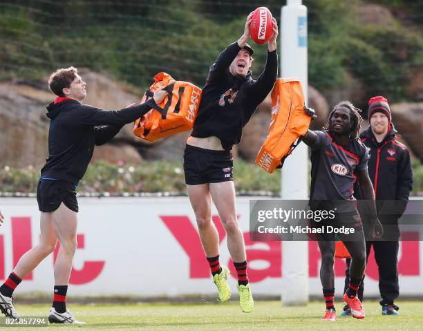 Patrick Ambrose and Anthony McDonald-Tipungwuti pressure Michael Hartley during an Essendon Bombers AFL media session at the Essendon Football CLub...