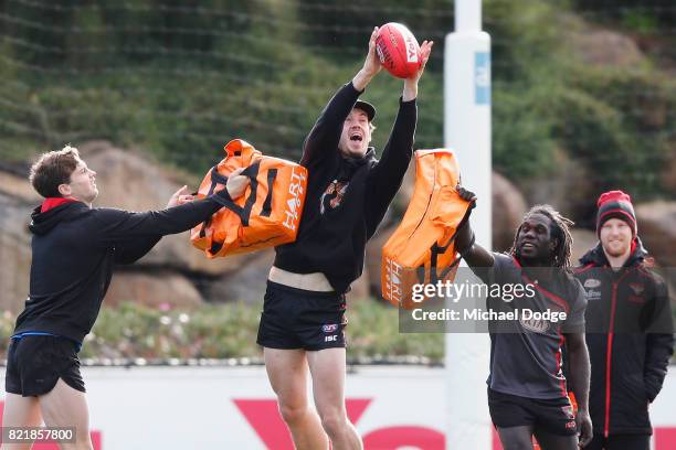 Patrick Ambrose and Anthony McDonald-Tipungwuti pressure Michael Hartley during an Essendon Bombers AFL media session at the Essendon Football CLub...