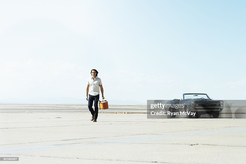 Man walking away from car with gas can