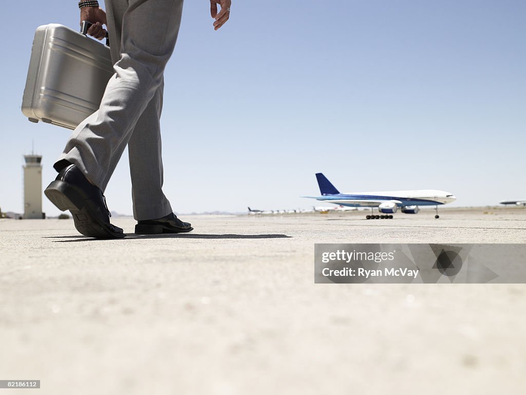 Business man walking toward airplane