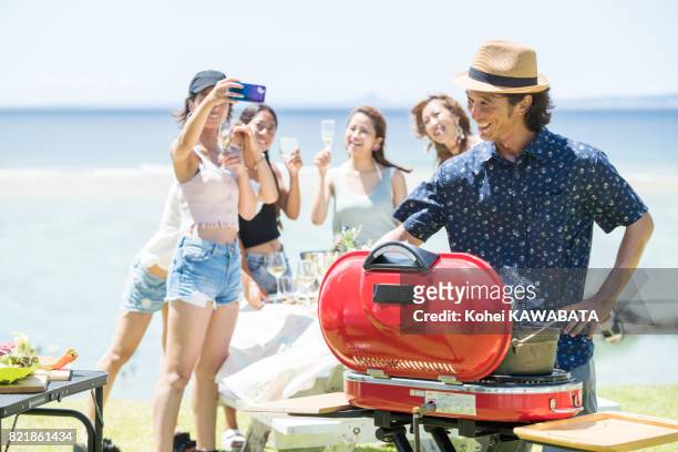 jonge vrouwen zijn plezier op de bbq - beach bbq stockfoto's en -beelden