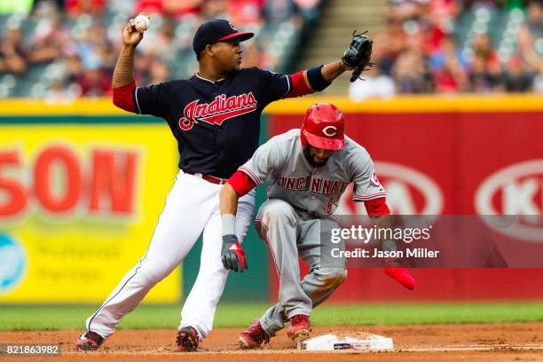 Second baseman Jose Ramirez of the Cleveland Indians throws out Zack Cozart of the Cincinnati Reds at first base as he runs into Billy Hamilton for a...