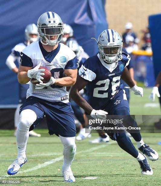 Ryan Switzer of the Dallas Cowboys catches a pass in front of Jameill Showers during training camp on July 24, 2017 in Oxnard, California.