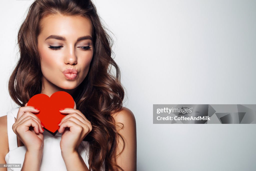 Beautiful woman holding artificial heart
