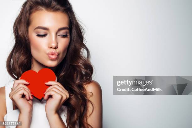 beautiful woman holding artificial heart - hair love stock pictures, royalty-free photos & images