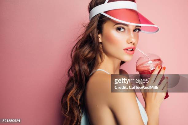 ziemlich coole mädchenmode trinkt aus der tasse über rosa hintergrund - fashion millinery woman stock-fotos und bilder