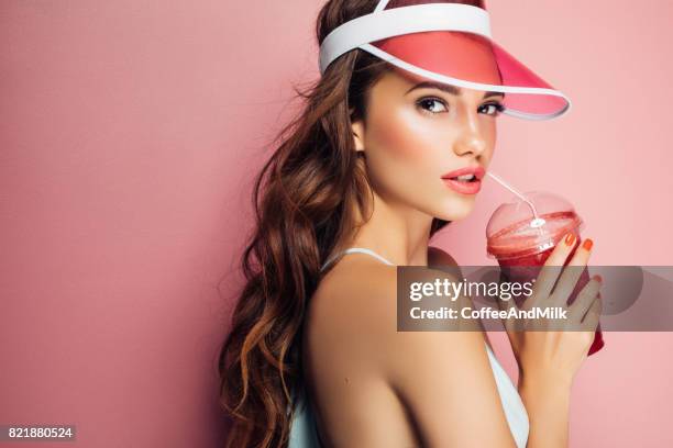 mode vrij koel meisje drinkt uit cup op roze achtergrond - attractive girl stockfoto's en -beelden