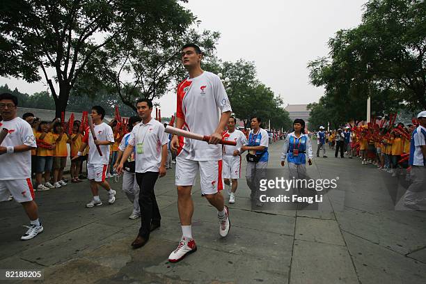 China's NBA star Yao Ming carries the Olympic torch before the start of the Olympic torch relay on Tiananmen Square on August 6, 2008 in Beijing,...