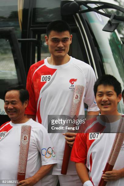 China's NBA star Yao Ming poses with the Olympic torch before the start of the Olympic torch relay on Tiananmen Square on August 6, 2008 in Beijing,...