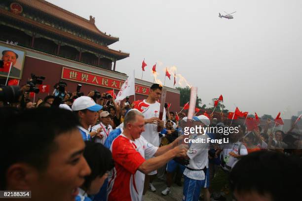 China's NBA star Yao Ming passes on the Olympic flame to Hein Verbruggen, chairman of the International Olympic Committee Coordination Commission, in...