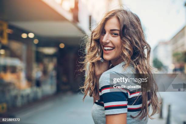 belle femme en arrière - regarder par dessus son épaule photos et images de collection