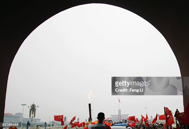 China's NBA star Yao Ming holds up the Olympic torch under the Tiananmen Gate during the Olympic torch relay on August 6, 2008 in Beijing, China.