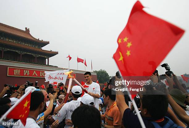 China's NBA star Yao Ming passes on the Olympic flame to Hein Verbruggen, chairman of the International Olympic Committee Coordination Commission, in...