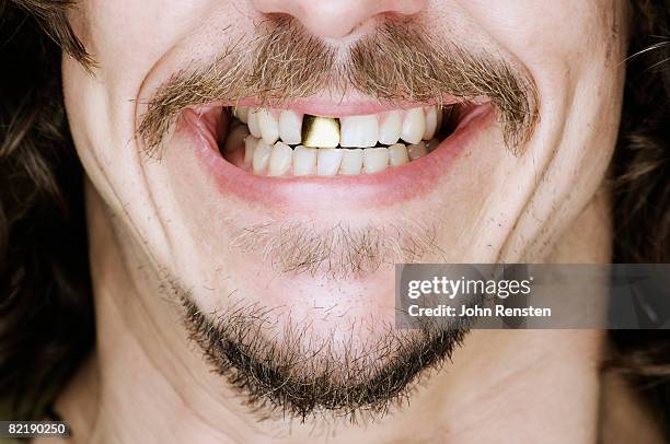 smiling gold tooth - clenching teeth stock-fotos und bilder