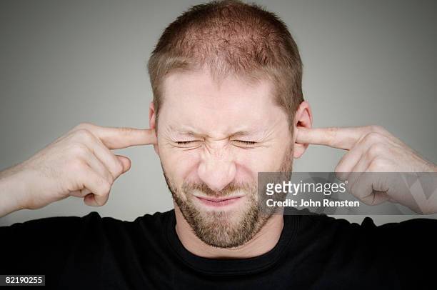 man with fingers in ears - vingers in de oren stockfoto's en -beelden