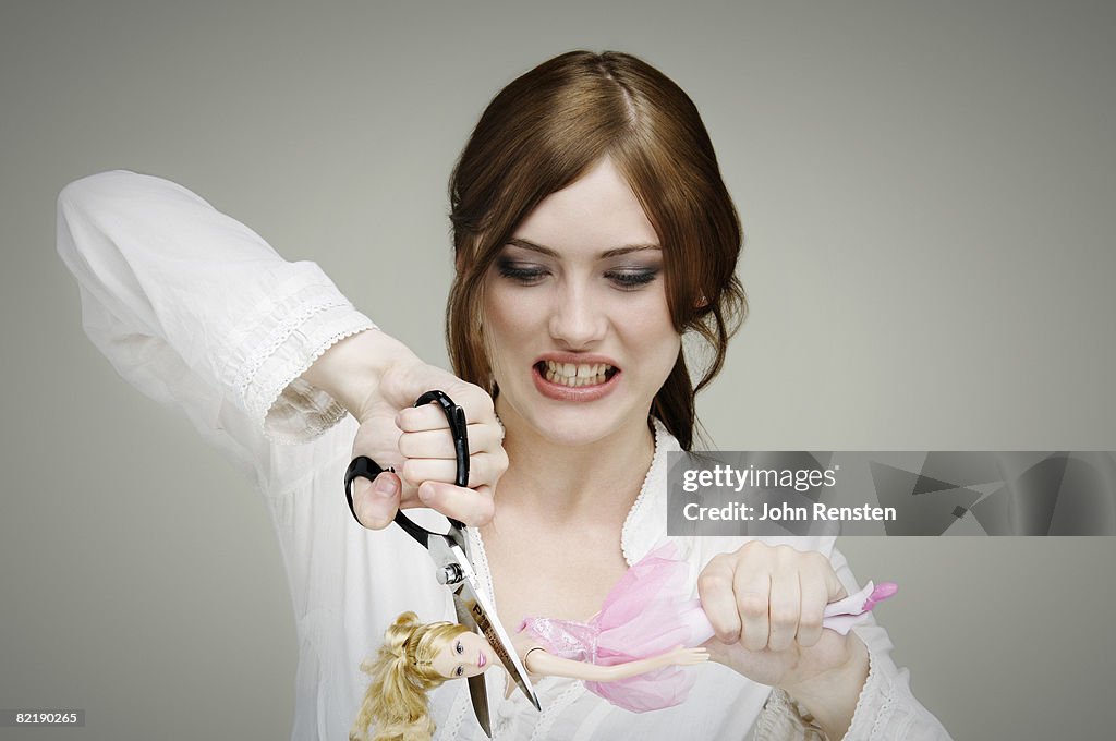 Girl cutting up doll