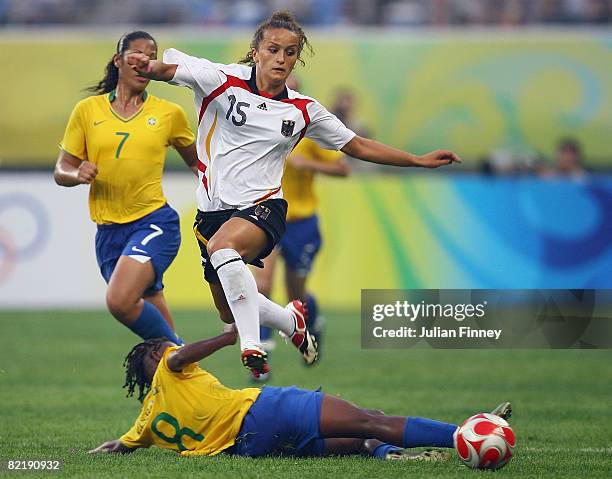 Fatmire Bajramaj of Germany skips over the challenge of Formiga of Brazil during the women's preliminary group F match between Germany and Brazil at...