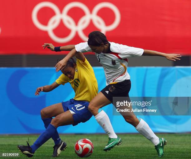 Marta of Brazil tangles with Linda Bresonik of Germany during the women's preliminary group F match between Germany and Brazil at Shenyang Stadium on...