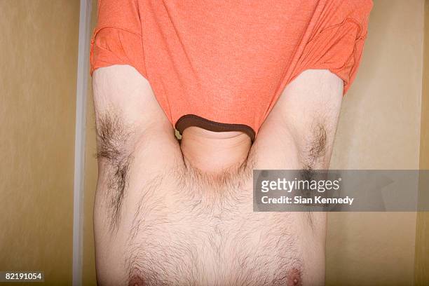 overweight man trying on clothing - stripping stockfoto's en -beelden