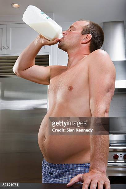 man with pot belly drinking milk from the jug - milk bottles stock pictures, royalty-free photos & images