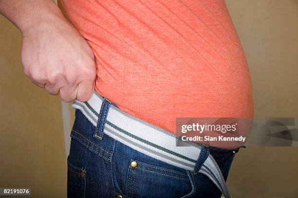 overweight man trying on clothing - human abdomen foto e immagini stock