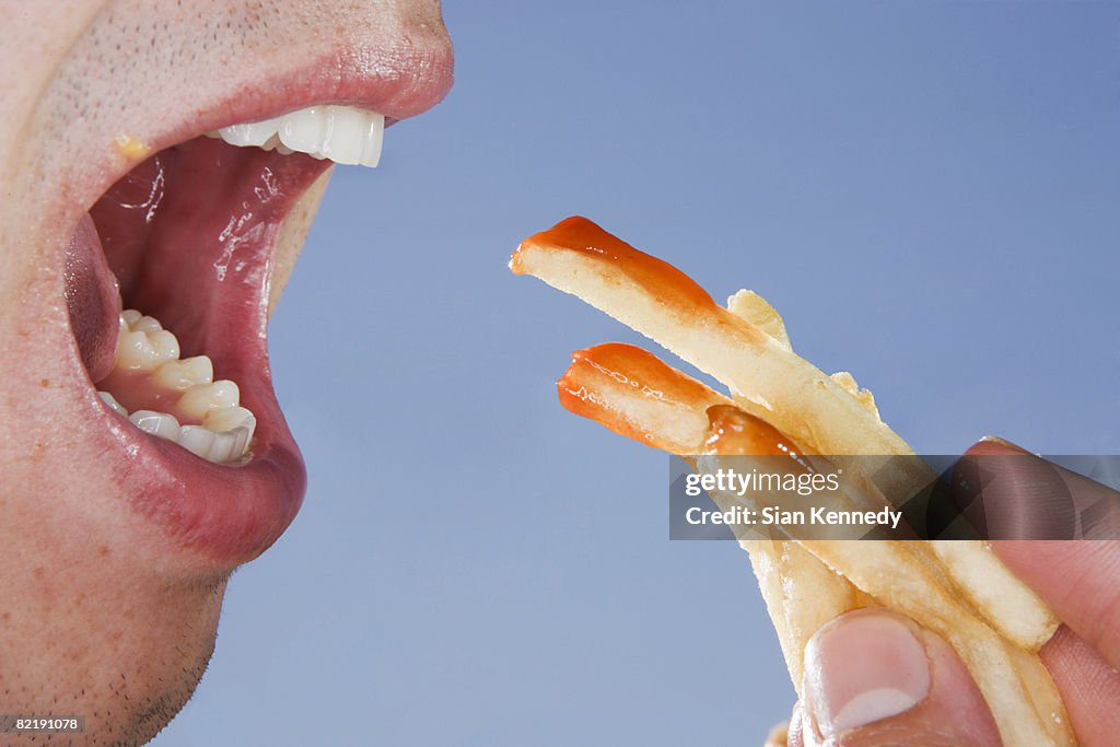 Close-up of someone eating french fries