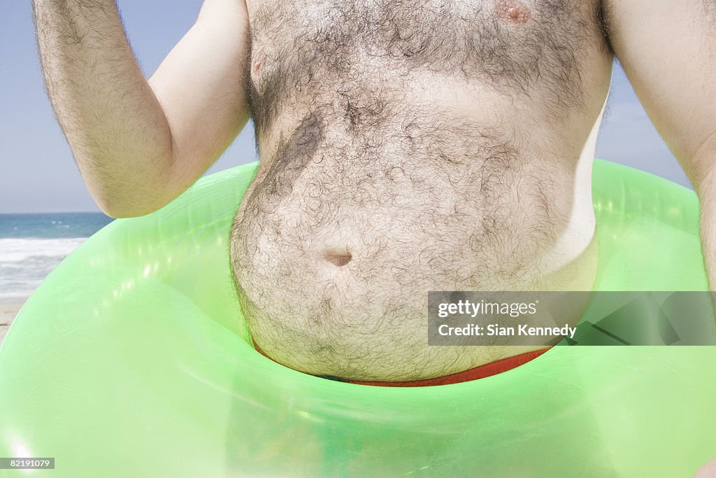 Man with pot belly on the beach