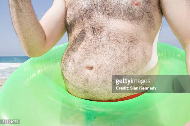 man with pot belly on the beach - barriga de cerveja imagens e fotografias de stock