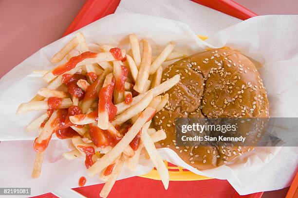 hamburger and french fries on a fast food tray - plateau stockfoto's en -beelden