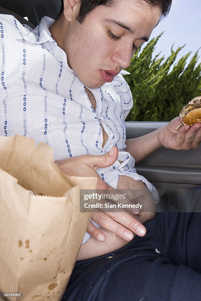 Man eating fast food in his car