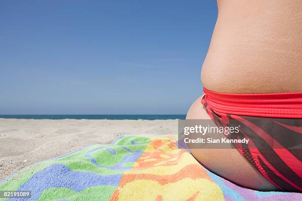 woman in bikini sitting on the beach, close-up - beach towel stock pictures, royalty-free photos & images