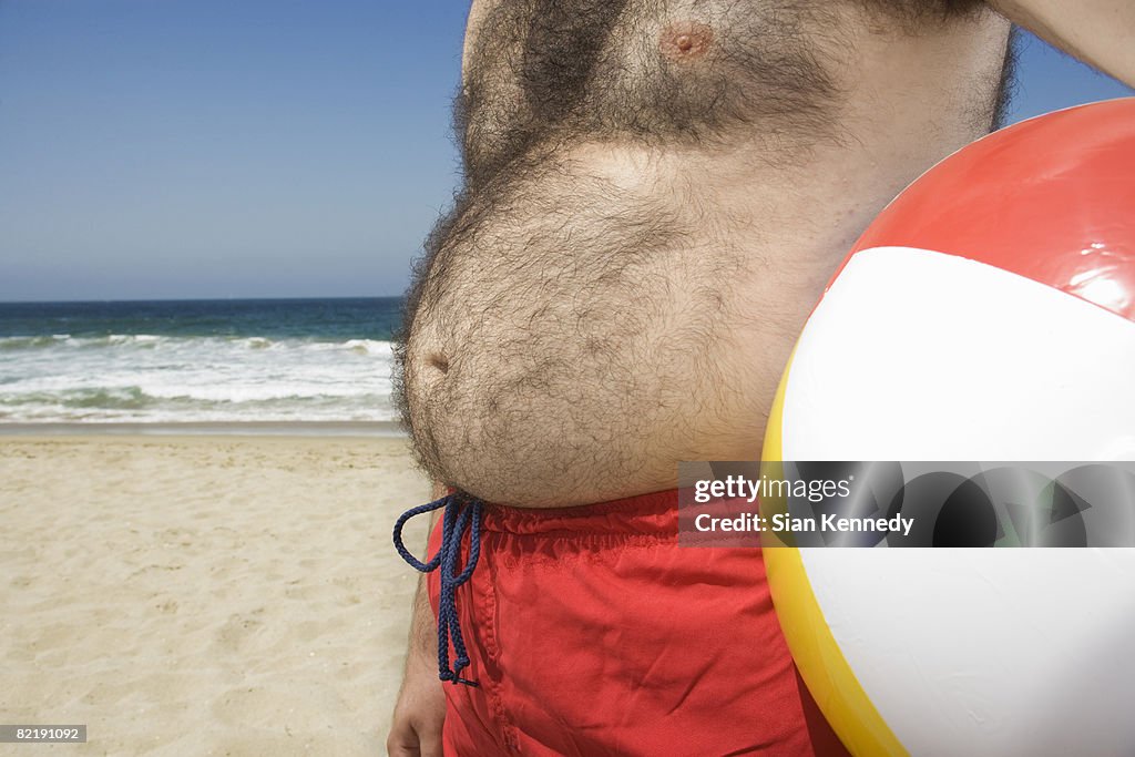 Man with pot belly at the beach