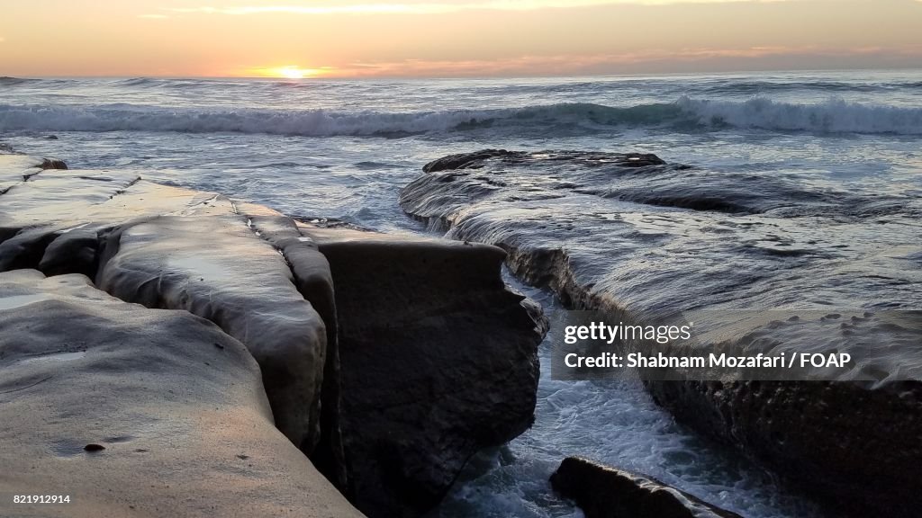 Waves on rocks at sunset