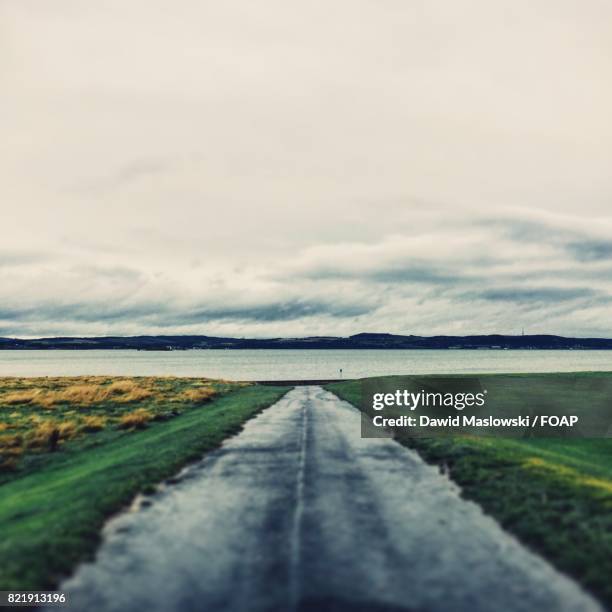 scenic view of road and lake - maslowski stock pictures, royalty-free photos & images