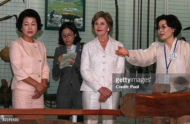 First lady Laura Bush , and South Korean First lady Kim Yoon-Ok listens to an South Korean tour guide during their visit to the National folk museum...