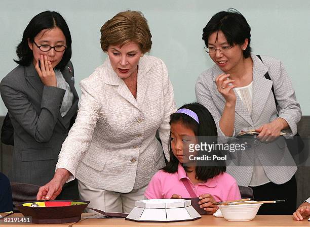 First lady Laura Bush listens to an South Korean tour guide during her visit to the National folk museum on Kyoungbok Palace in Seoul, South Korea,...
