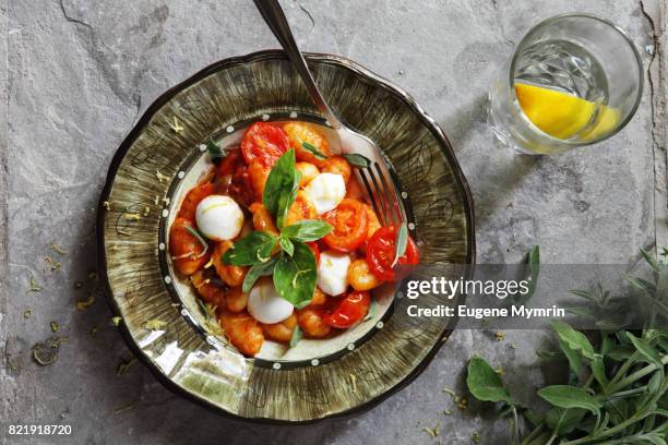 gnocchi with tomato sauce, mozzarella and herbs - pasta tomato basil stock pictures, royalty-free photos & images