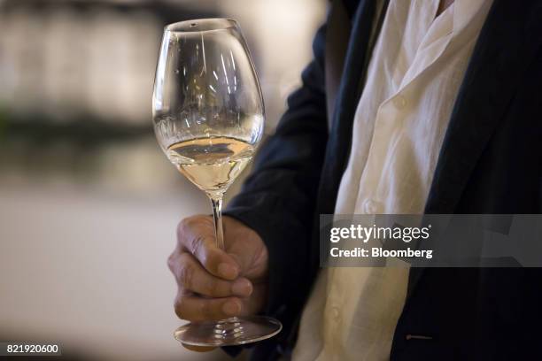 Customer holds a glass of sparkling sake at the Japan Awasake Association booth during a Sake Marche event at the Isetan Shinjuku department store,...