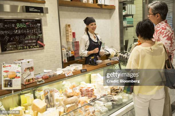 Customers shop for cheese at a counter in the Isetan Shinjuku department store, operated by Isetan Mitsukoshi Holdings Ltd., in Tokyo, Japan, on...