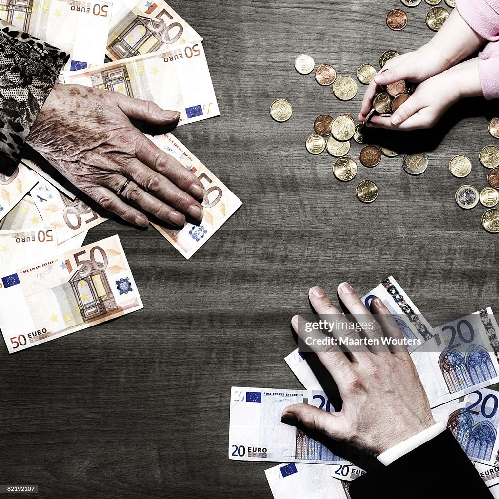 3 people's hands with money on table