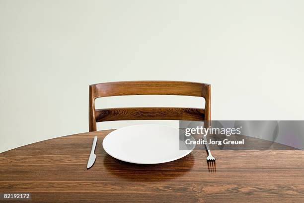 empty plate with knife and fork on table - plate fotografías e imágenes de stock