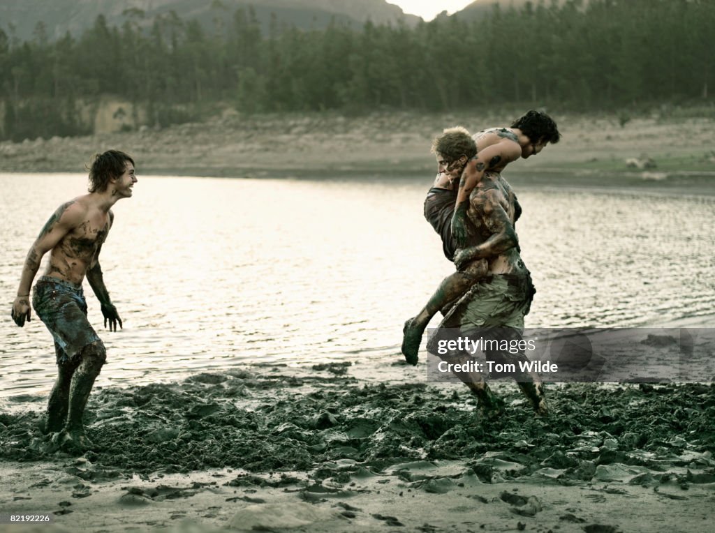Three boys playing in mud
