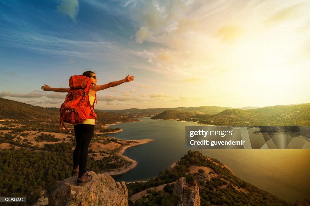 Successful woman backpacker enjoy the view at mountain peak