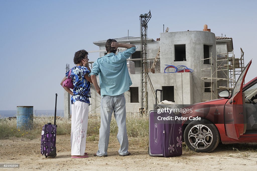 Couple stood in front of half built villa