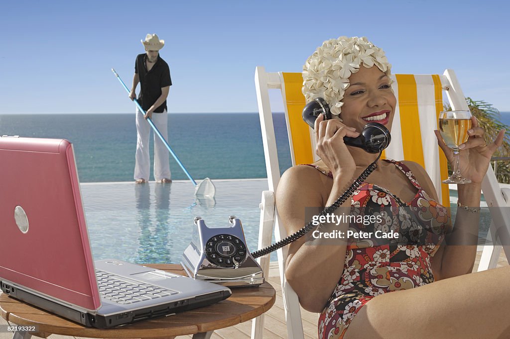 Woman sat by pool on phone