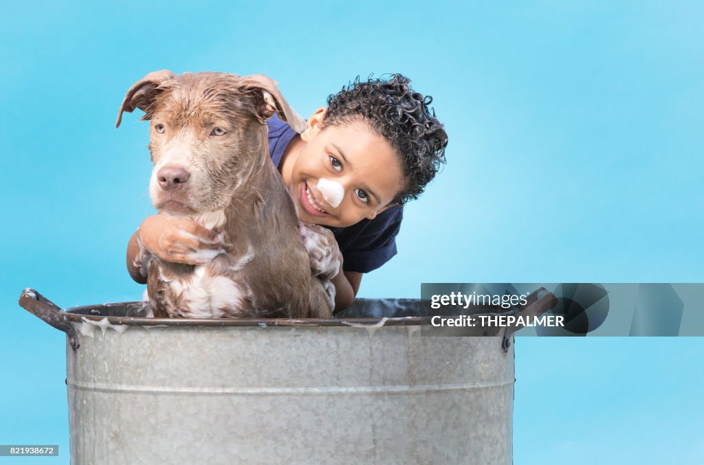 Boy bathing his dog