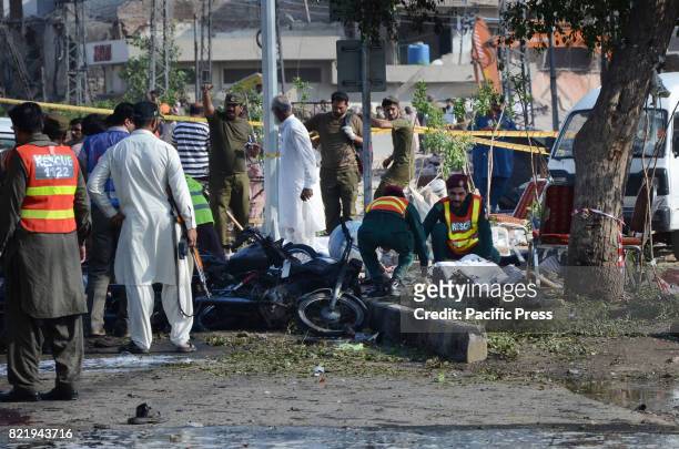 Pakistani security officials collect evidence from the scene of a blast. At least 29 people were killed and 55 injured on a suicide attack in...