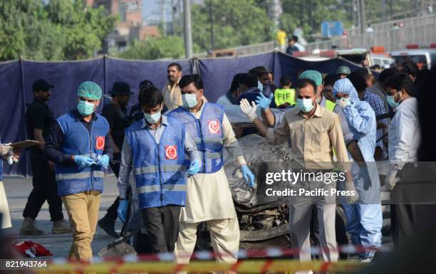 Pakistani security officials collect evidence from the scene of a blast. At least 29 people were killed and 55 injured on a suicide attack in...