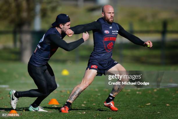 Nathan Jones fends off Tomas Bugg during a Melbourne Demons AFL training session at Gosch's Paddock on July 25, 2017 in Melbourne, Australia.